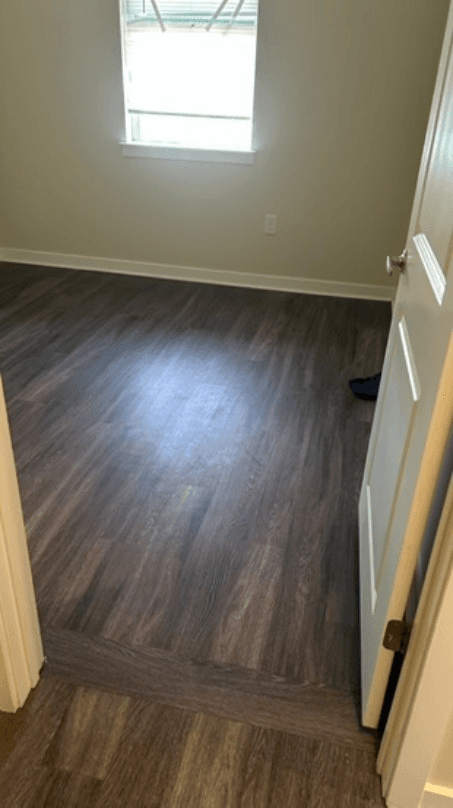 Graphite-toned luxury vinyl plank in a bedroom